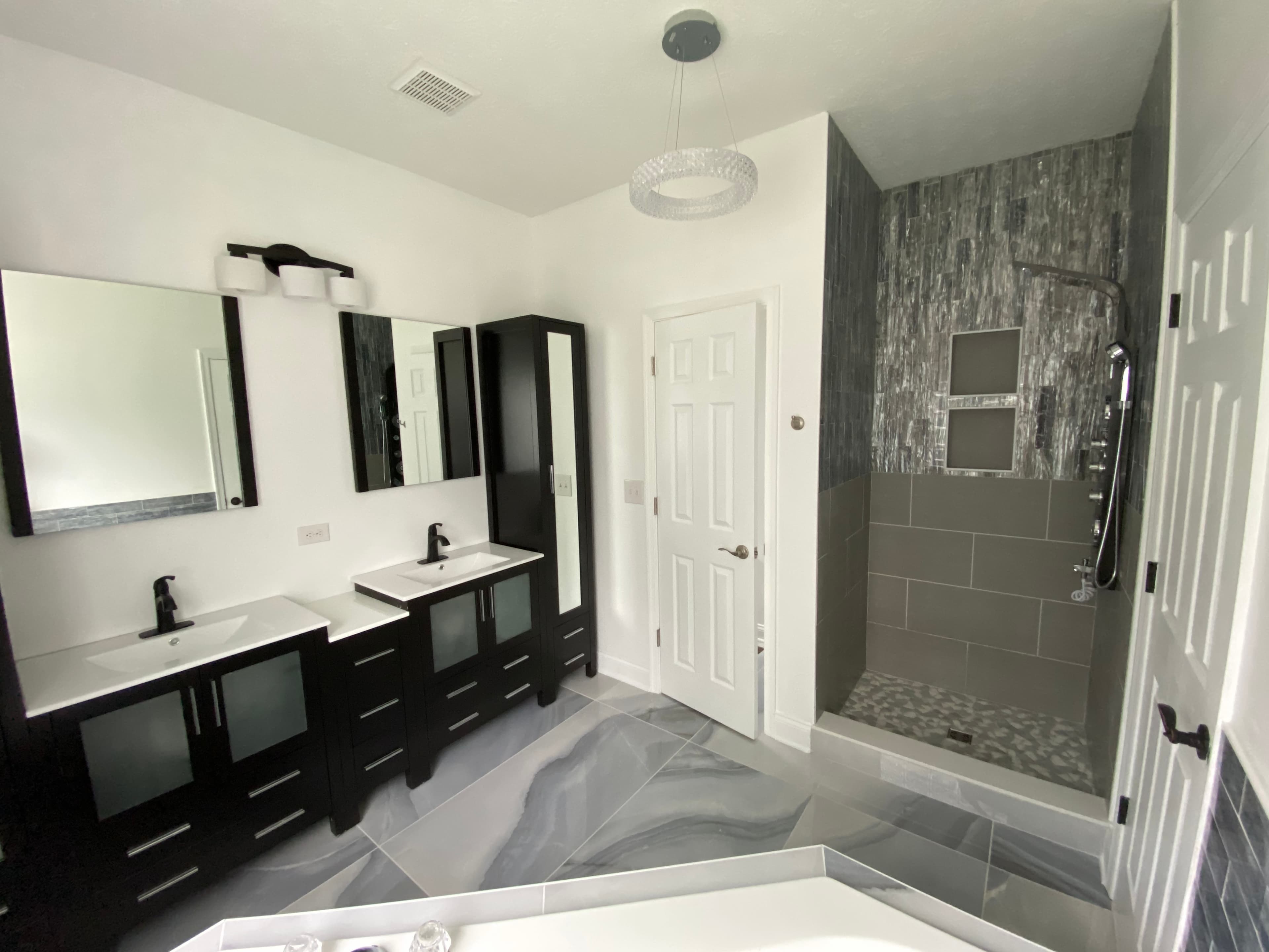 Remodeled bathroom with a double vanity and custom tiled walk-in shower